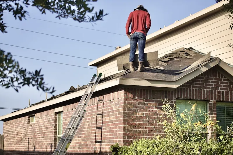 Professional roofer working on a residential roof in North Pembroke